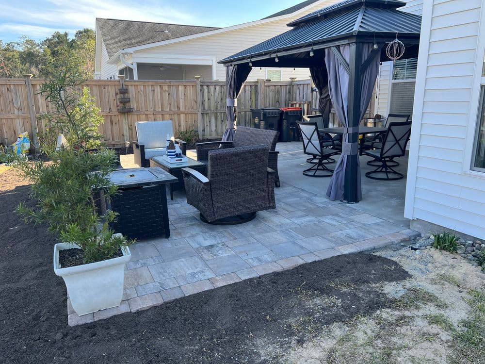 cozy backyard patio with seating area, gazebo, and decorative plants in a landscaped setting